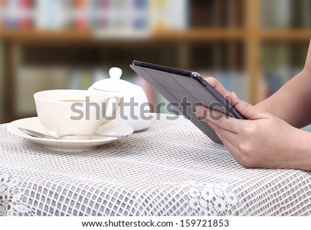 Closeup images of asian woman touch her tablet and hot coffee