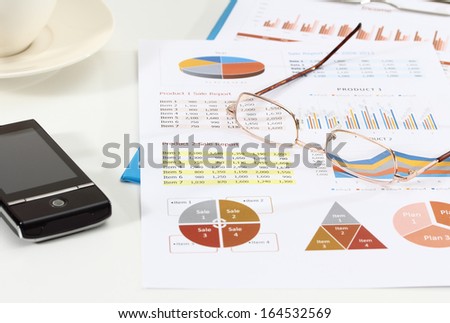 image of graphics and finance report for business with glasses and mobile phone