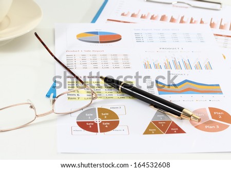image of graphics and finance report for business with pen and glasses