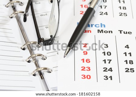 closeup image of pen and glasses on business book and calendar for working