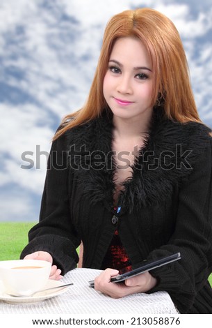 beautiful asian woman with hot coffee and tablet on table