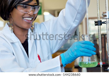 Happy smiling female researcher in chemical lab.