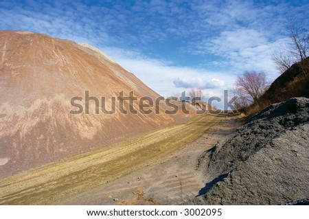 Artificial stone hill and road to clouds. Shot in March, in a stone open-cast mine, Poltavska Region, Ukraine