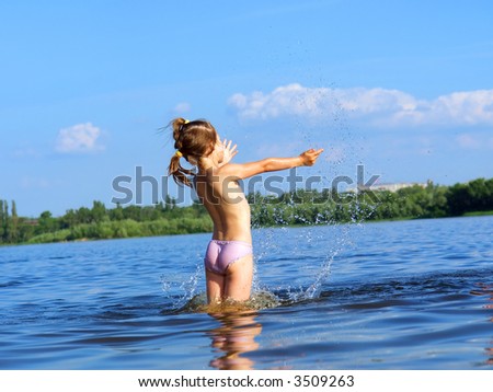 Life is beautiful - happy girl makes a water splash - in sunset light. Shot in June, near Dnieper river, Ukraine.