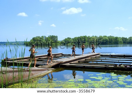 Six kids run through bridge to jump into morning river. Shot in June, near Dnieper river, Ukraine.