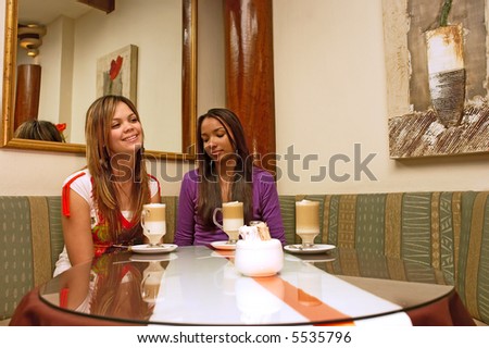 Two mulatto girls sit in a cafe with mirrors. Shot in Western Cape, South Africa.