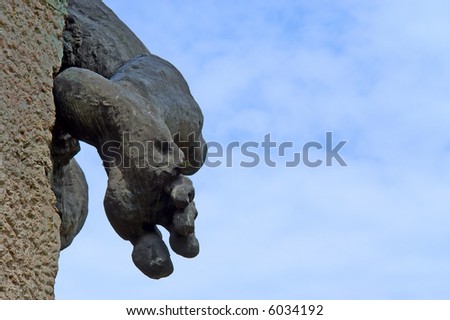 Closeup of foot of sculpture made from black stone against sky. Shot in Kyiv, Ukraine.
