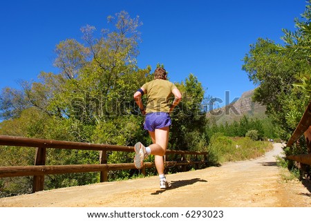 Runner on bridge - and misty majestic mountains as a background. Shot  in Jonkershoek Nature Reserve, Stellenbosch, Western Cape, South Africa.