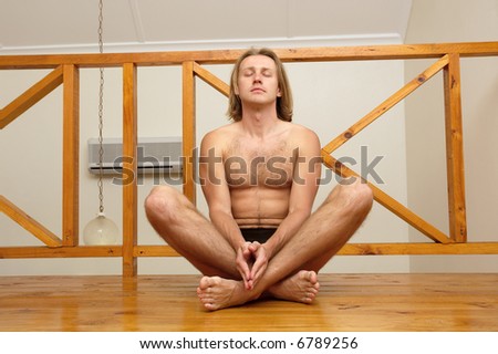 Relaxed man with bare chest meditates in lotus pose. Shot in South Africa.