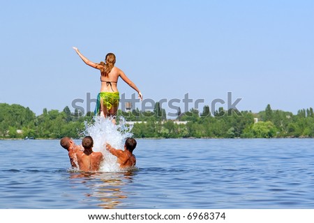 \'Rocket girl\' - three boy launch girl high to jump into water. Shot in June, near Dnieper river (Dniepropetrovsk, Ukraine).