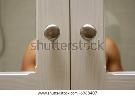Closeup of bath box handles and reflection of naked shoulders (focus on buttons). Shot in South Africa.