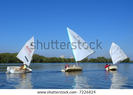 Three small yachts on river. Shot in July, Dnieper river, Ukraine.