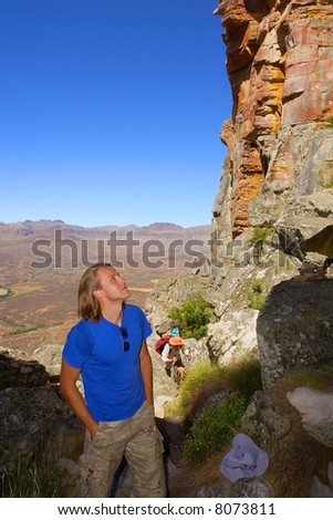Young man looks up at rocks. Shot in Wolfberg Mountains, Cederberg, Western Cape, South Africa.