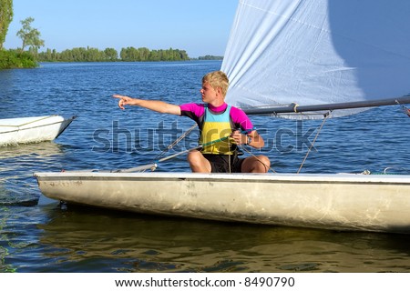 Teen yachtsman points with his finger. Shot in July, Dnieper river, Ukraine.