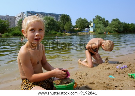 Smiling girl - kids play on beach in hot summer day. Shot in July, Ukraine.