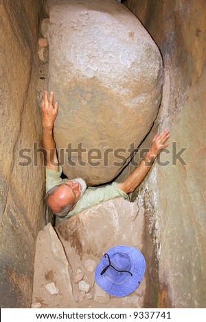 Old man gets stuck between rocks. Shot in Wolfberg Mountains, Cederberg, Western Cape, South Africa.