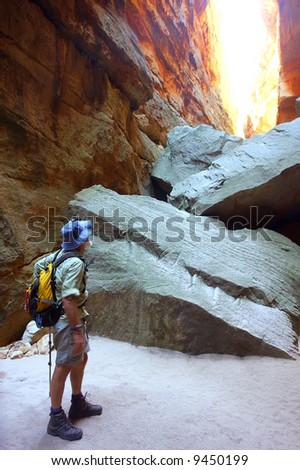 Old man looks up from cave (motion blur of hands). Shot in Wolfberg Cracks, Cederberg, Western Cape, South Africa.