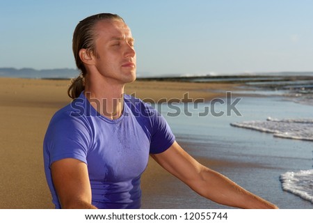 Young businessman meditates on beach - closeup. Shot in Sodwana Bay Nature Reserve, KwaZulu-Natal province, Southern Mozambique area, South Africa.