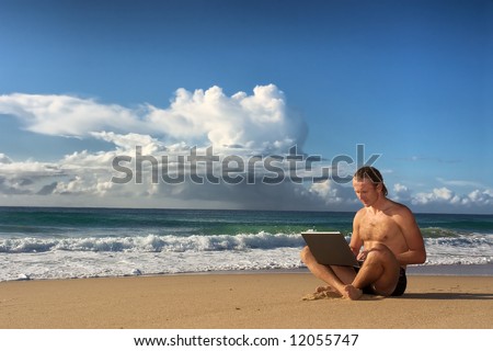 Young business man with notebook on beach under dramatic skies. Shot in Sodwana Bay nature reserve, KwaZulu-Natal province, Southern Mozambique area, South Africa.