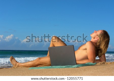 Young man sunbathing with notebook on beach. Shot in Sodwana Bay nature reserve, KwaZulu-Natal province, Southern Mozambique area, South Africa.