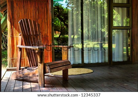 chair next to glass doors of vacation house in camp's park. Shot in Sodwana Bay campsite, KwaZulu-Natal province, Southern Mozambique area, South Africa.