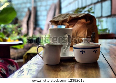 Coffee set cups and paper pack on table in restaurant. Shot in Sodwana Bay, KwaZulu-Natal, South Africa and Southern Mozambique.