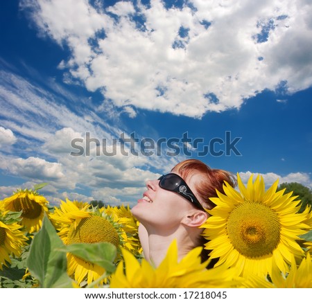 \'Kissed by sun\' - red-hair girl looks up in the skies - closeup of head among sunflowers. Shot in Ukraine.