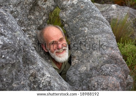 Happy old man in rocky 'window'. Shot on Stellenbosch Mountain, Western Cape, South Africa.