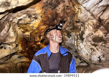 Young man with headlamp in a cave. Shot in Table Mountain Nature Park, near Cape Town, South Africa.