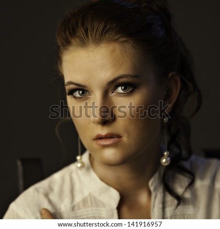 Portrait of woman on gray background. She gaze