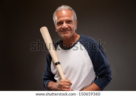 Smiling senior man with a baseball bat