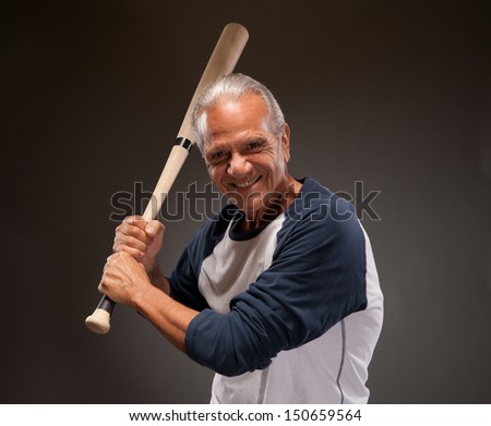 Happy senior adult man with baseball bat
