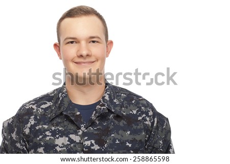 Portrait of smiling young man in navy uniform against white background