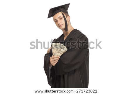 Portrait of student in graduation gown holding money against white background