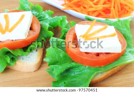 Orange carrots tomato, salad and soy on light bread for healthy, but fast snack, meal.