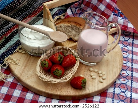 milk, sour cream and strawberries on the wooden plate with towels