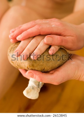 ayurvedic oil massage procedure with pouch of rice and spices