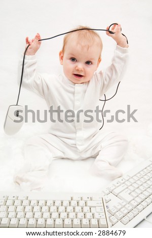 little girl playing with two computer keyboards and mouse