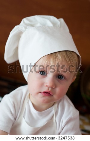 little boy in the cook costume at the kitchen