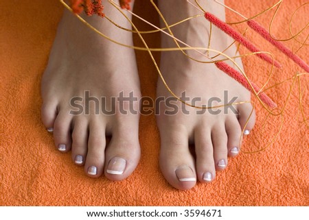 young female foot with pedicure on towel with some floral elements