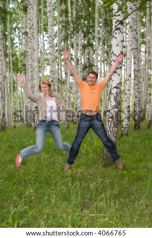 two happy people jumping in the forest