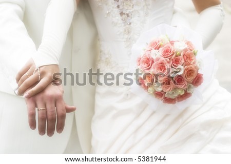 just married - young couple in wedding wear with bouquet of roses. Soft-focused image in high key