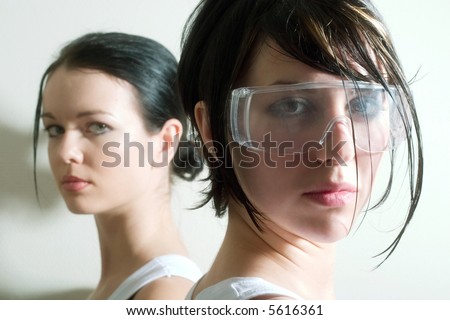 two attractive girls looking into the camera. Focal point is on the right face.