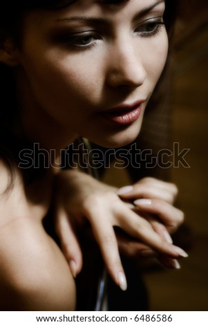 Mysterious low-key portrait of beautiful glamorous woman. Soft-focused. Focus is on eye