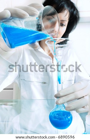 Woman scientist performs some experiment. Special blue toned photo f/x.
