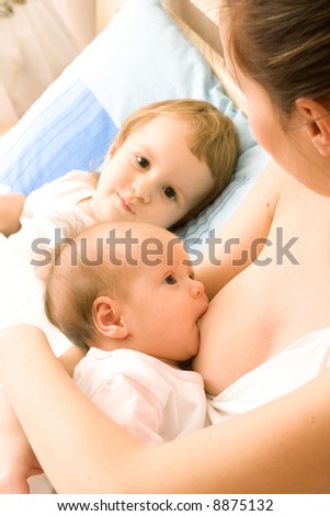 Mother with two daughters, breastfeeding baby