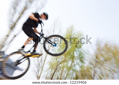 Boy on a bmx/mountain bike jumping. Motion blur photo f/x