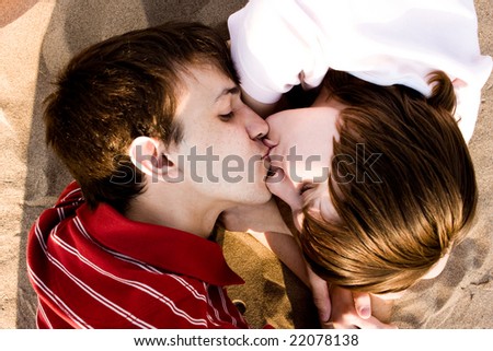two young loving people kissing at the beach