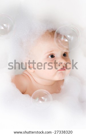 Cute baby having bath in the foam