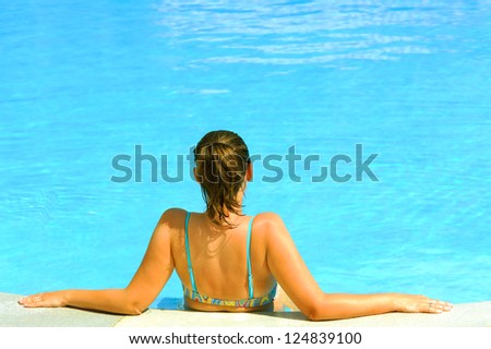Young attractive female beauty posing in the swimming pool